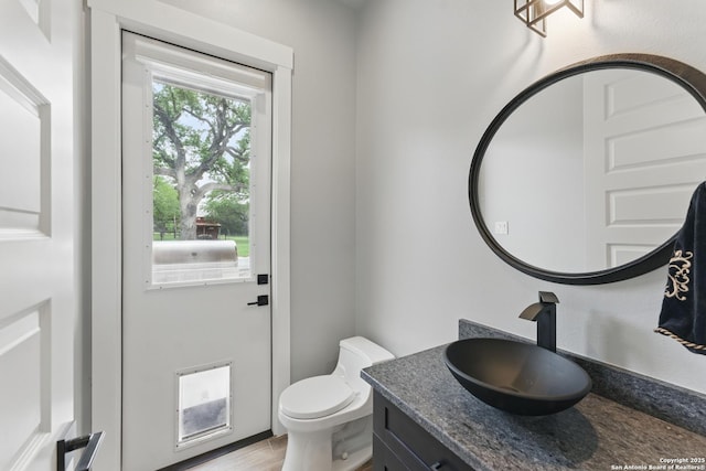 821 Bingham Ln, New Braunfels, TX 78132 - half bathroom featuring toilet, vanity, and wood finished floors