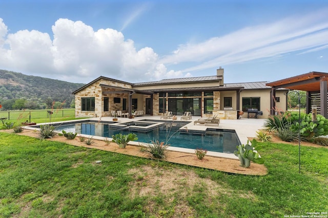 821 Bingham Ln, New Braunfels, TX 78132 - back of property featuring a patio, a standing seam roof, a chimney, and a lawn