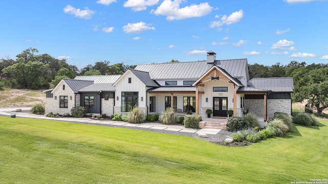 view of front of property with a front yard and a standing seam roof