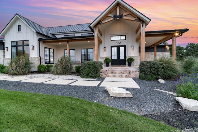 exterior space featuring metal roof, french doors, a porch, and board and batten siding