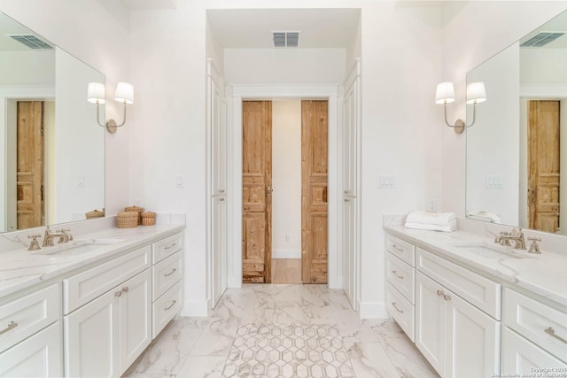 bathroom featuring marble finish floor, visible vents, and a sink