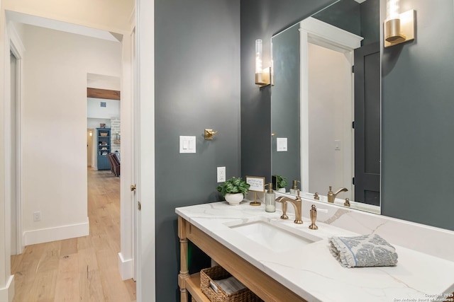 bathroom featuring baseboards, vanity, and wood finished floors