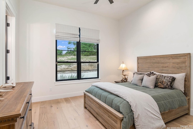bedroom featuring baseboards, ceiling fan, and light wood-type flooring