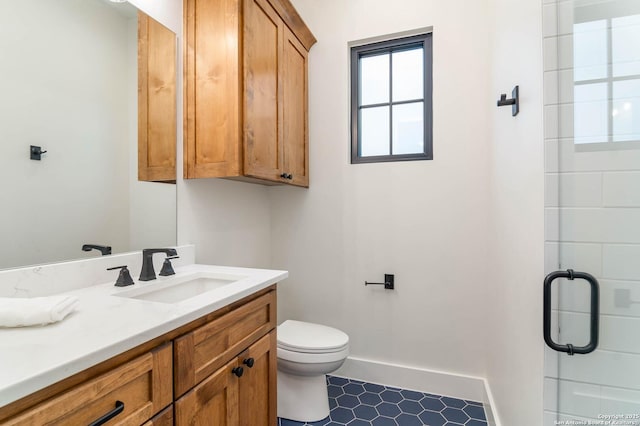 full bath with a stall shower, vanity, toilet, and baseboards