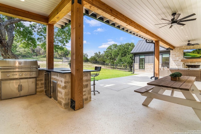 view of patio / terrace with ceiling fan, exterior kitchen, grilling area, and fence