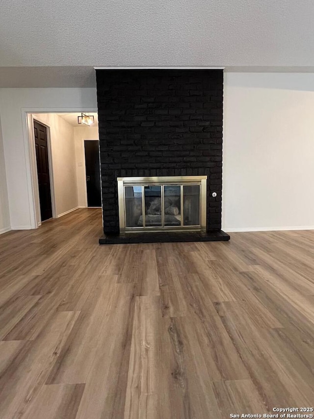 10106 Grand Park, San Antonio, TX 78239 - interior details with a textured ceiling, wood finished floors, baseboards, and a brick fireplace