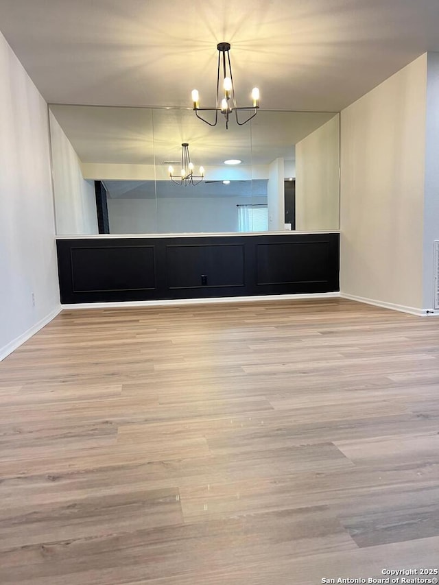 10106 Grand Park, San Antonio, TX 78239 - spare room with wood finished floors, baseboards, and a notable chandelier