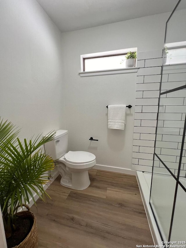 10106 Grand Park, San Antonio, TX 78239 - bathroom with toilet, a tile shower, baseboards, and wood finished floors