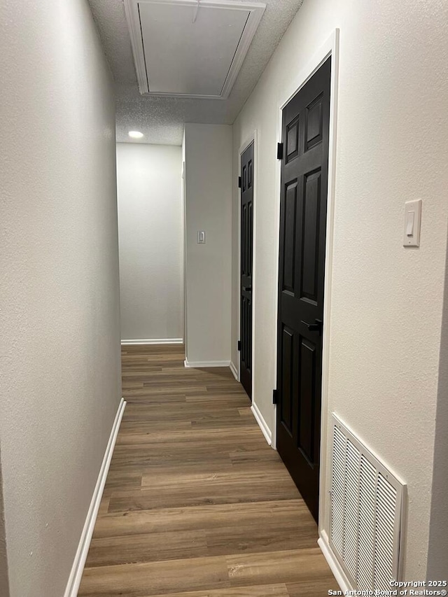 10106 Grand Park, San Antonio, TX 78239 - hallway with baseboards, visible vents, attic access, and wood finished floors