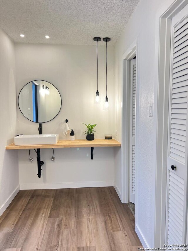 10106 Grand Park, San Antonio, TX 78239 - hall with a textured ceiling, wood finished floors, baseboards, and a sink