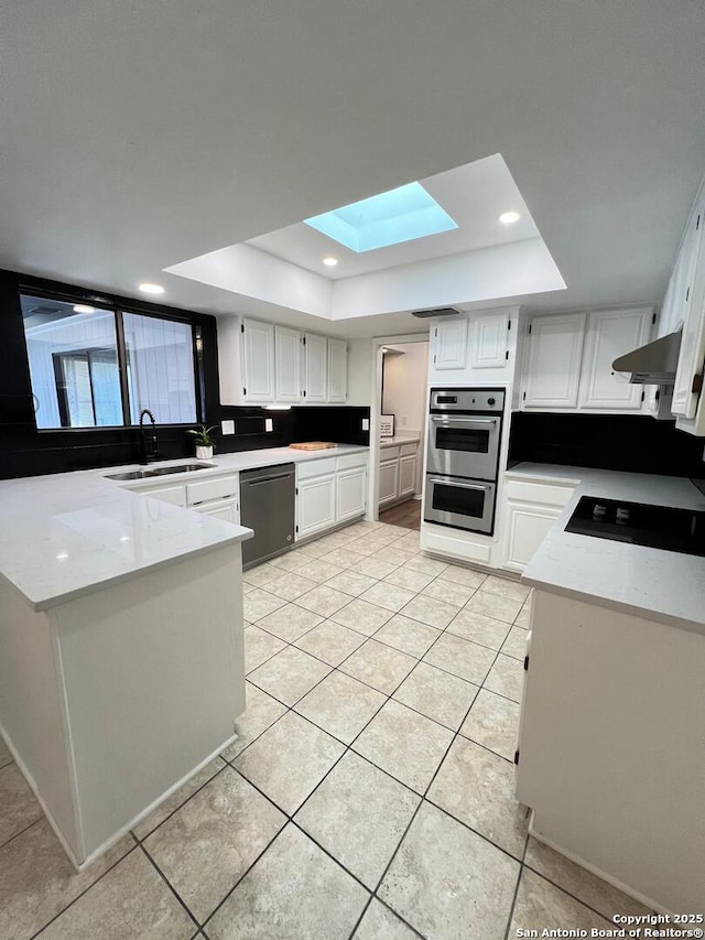 10106 Grand Park, San Antonio, TX 78239 - kitchen with a tray ceiling, light tile patterned flooring, a sink, dishwashing machine, and a skylight