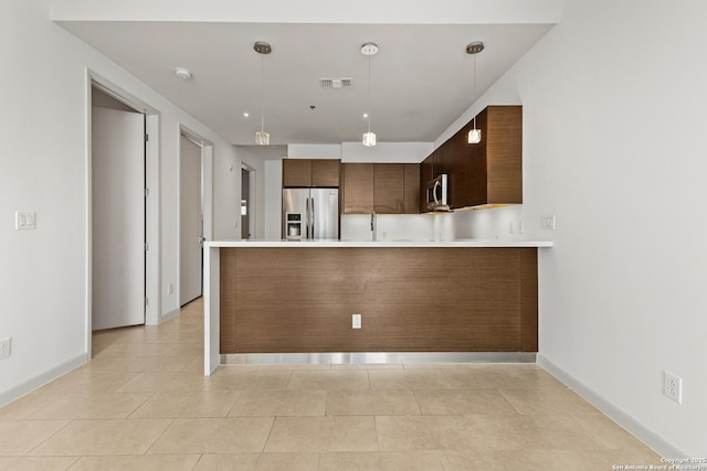 kitchen featuring light countertops, stainless steel appliances, a peninsula, and visible vents