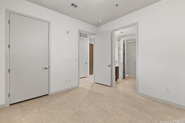 unfurnished bedroom with baseboards and visible vents