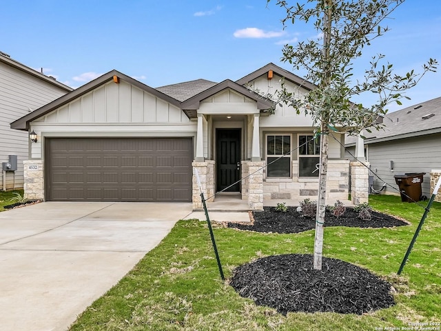 4532 Appaloosa Crst, San Antonio, TX 78245 - view of front of home with an attached garage, stone siding, concrete driveway, a front yard, and board and batten siding