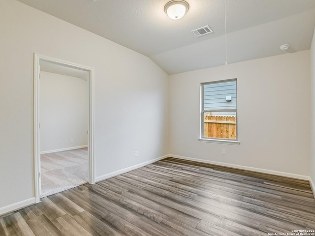 4532 Appaloosa Crst, San Antonio, TX 78245 - empty room with vaulted ceiling, baseboards, visible vents, and wood finished floors