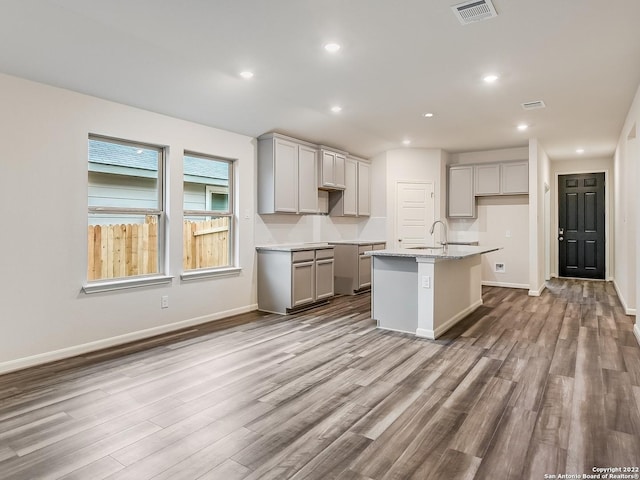 4532 Appaloosa Crst, San Antonio, TX 78245 - kitchen with an island with sink, visible vents, gray cabinetry, and wood finished floors