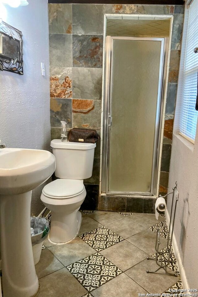 724 Holmgreen, San Antonio, TX 78220 - full bathroom with a stall shower, tile patterned floors, toilet, and a sink