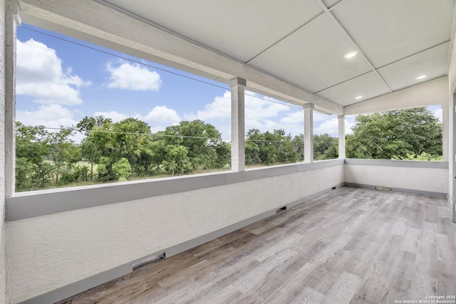 unfurnished sunroom featuring recessed lighting and wood finished floors