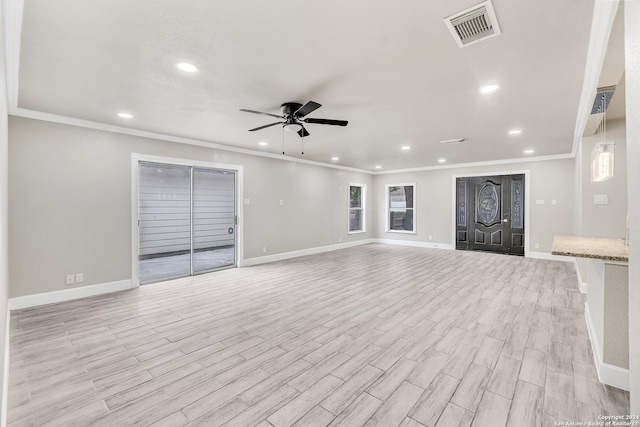 unfurnished living room featuring ornamental molding, baseboards, a ceiling fan, and visible vents