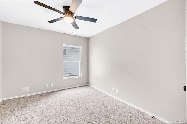 carpeted empty room featuring baseboards and a ceiling fan