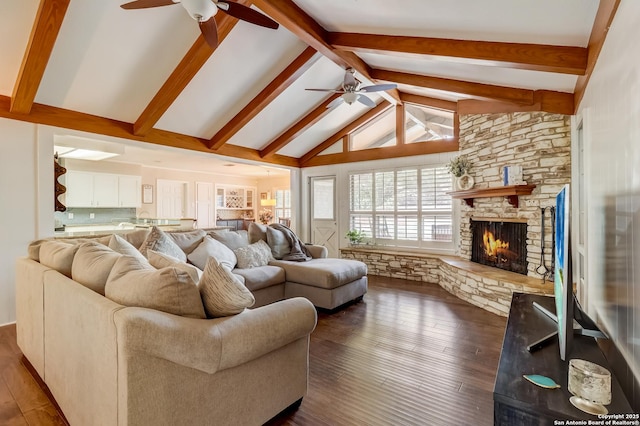 living room featuring ceiling fan, beamed ceiling, a stone fireplace, dark wood-style flooring, and high vaulted ceiling