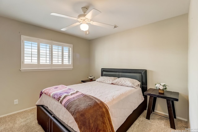 bedroom with light colored carpet, baseboards, and ceiling fan