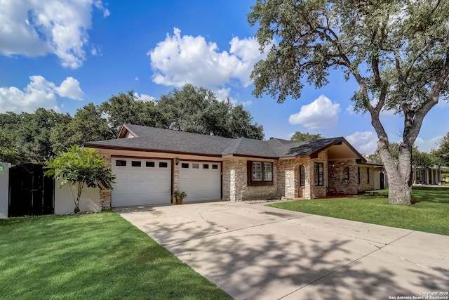ranch-style house with an attached garage, concrete driveway, a front yard, brick siding, and roof with shingles