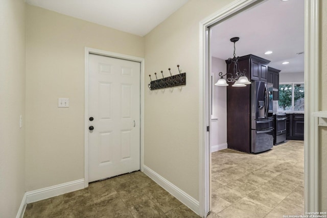 doorway to outside featuring baseboards and recessed lighting