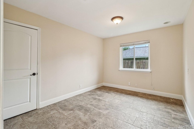unfurnished room with baseboards
