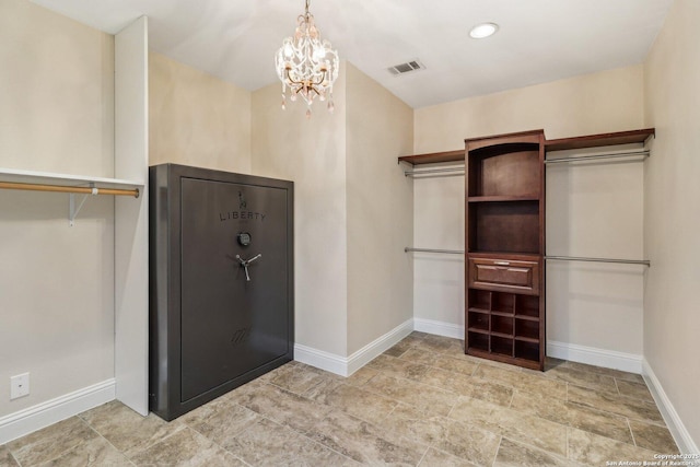 spacious closet with a chandelier and visible vents