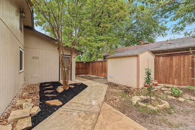 view of yard featuring a storage shed, an outdoor structure, and a fenced backyard