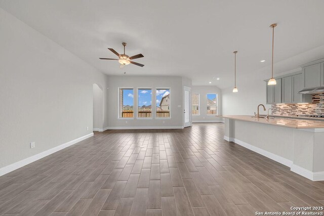 5303 Pinder Way, Schertz, TX 78108 - unfurnished living room featuring dark wood-type flooring, baseboards, ceiling fan, and recessed lighting