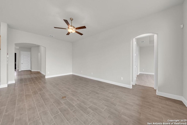 5303 Pinder Way, Schertz, TX 78108 - unfurnished living room with arched walkways, a ceiling fan, baseboards, and wood finished floors