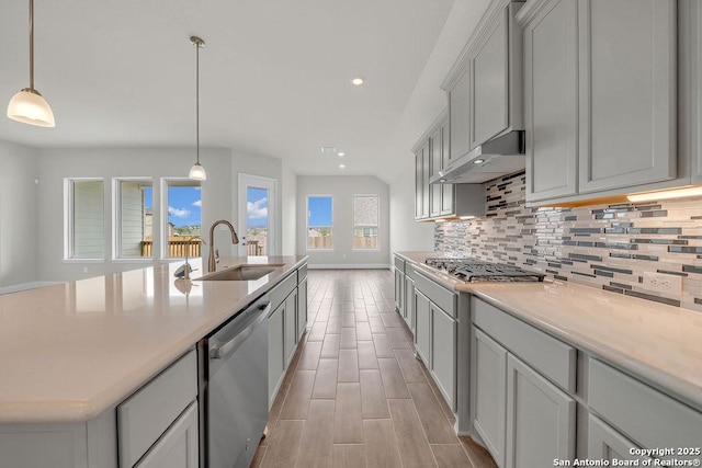 5303 Pinder Way, Schertz, TX 78108 - kitchen with a sink, stainless steel appliances, under cabinet range hood, light countertops, and decorative backsplash