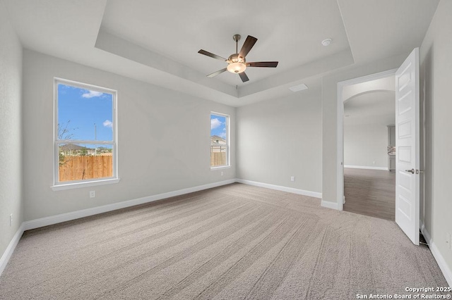 5303 Pinder Way, Schertz, TX 78108 - unfurnished room featuring a ceiling fan, carpet floors, baseboards, a raised ceiling, and arched walkways