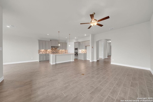 5303 Pinder Way, Schertz, TX 78108 - unfurnished living room featuring a ceiling fan, visible vents, baseboards, arched walkways, and recessed lighting