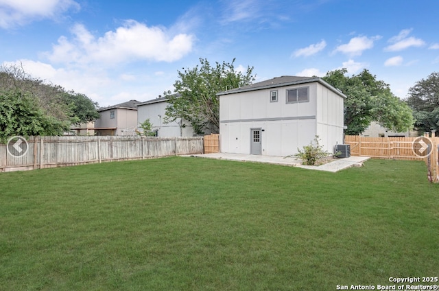 back of house with central air condition unit, a patio area, a fenced backyard, and a lawn