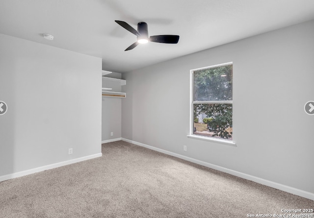 spare room with ceiling fan, carpet, and baseboards