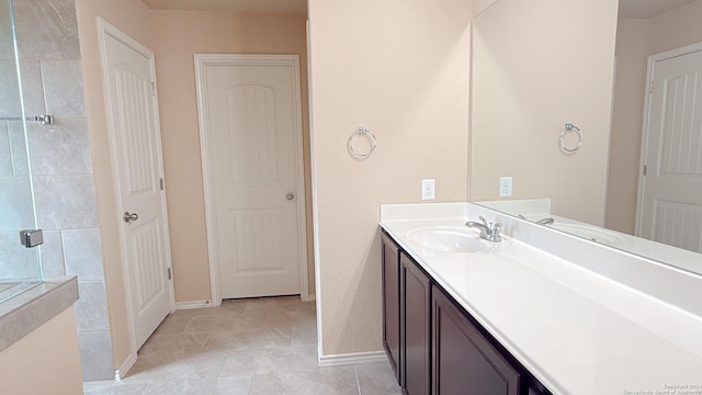 8411 Puente, San Antonio, TX 78223 - bathroom featuring vanity, baseboards, and tiled shower