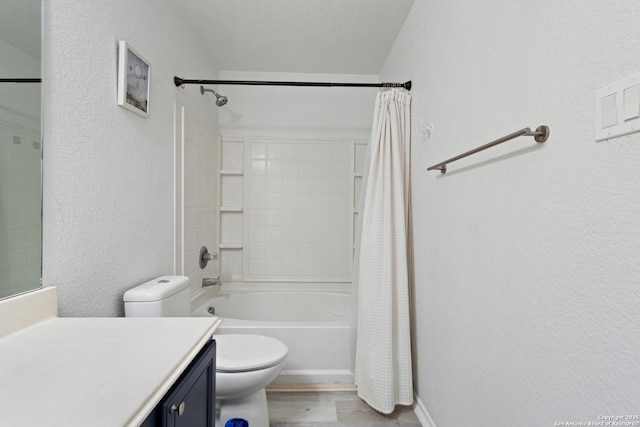 bathroom featuring shower / bath combo with shower curtain, toilet, baseboards, vanity, and a textured wall