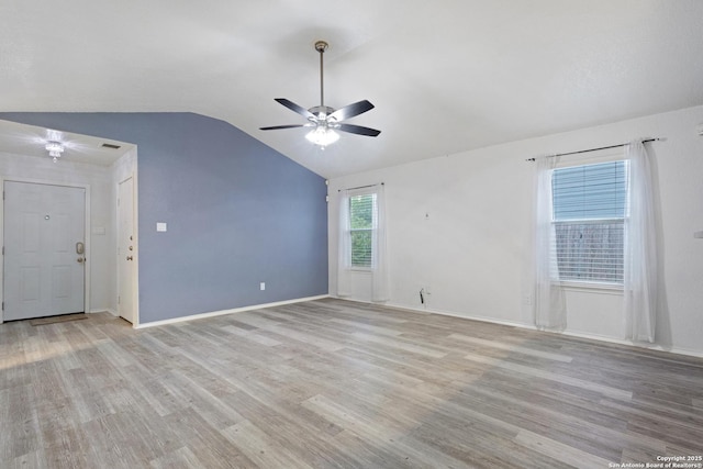 unfurnished room featuring light wood finished floors, baseboards, lofted ceiling, and a ceiling fan