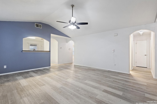 unfurnished living room featuring lofted ceiling, wood finished floors, visible vents, ceiling fan, and arched walkways