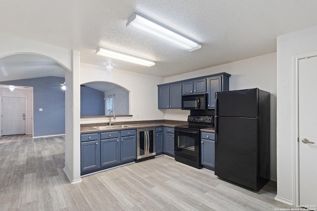 kitchen featuring wine cooler, ceiling fan, a sink, arched walkways, and black appliances