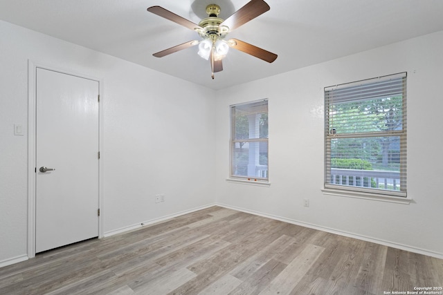 spare room with light wood-type flooring, baseboards, and ceiling fan