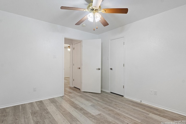 spare room with light wood finished floors, baseboards, and a ceiling fan