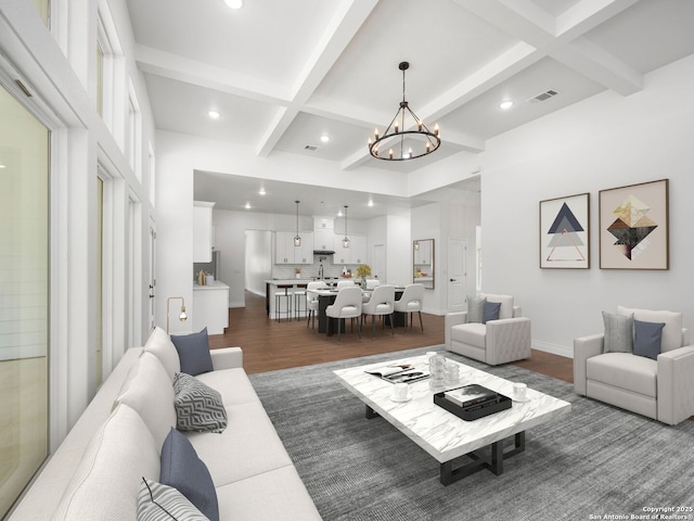 living area featuring recessed lighting, coffered ceiling, dark wood-type flooring, and an inviting chandelier