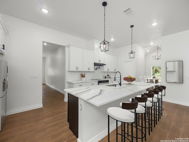 kitchen featuring dark wood-type flooring, baseboards, and a sink