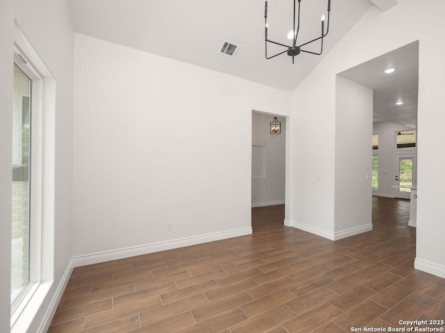 empty room with baseboards, an inviting chandelier, visible vents, and wood finished floors