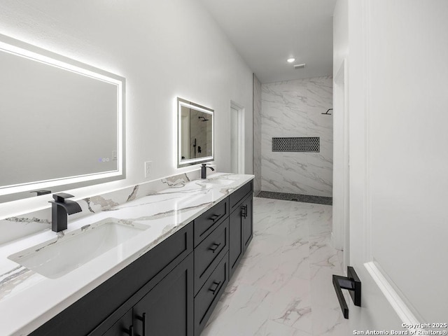 bathroom with double vanity, a marble finish shower, marble finish floor, and a sink