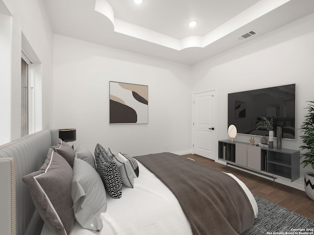 bedroom with wood finished floors, a tray ceiling, visible vents, baseboards, and recessed lighting